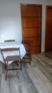 ein Schlafzimmer mit einem Bett, zwei Stühlen und einer Tür in der Unterkunft Casa confortável! in Uruguaiana