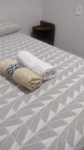 dos toallas sentadas encima de una cama en Casa confortável! en Uruguaiana