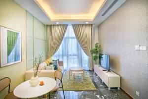 - un salon avec une télévision et une table dans l'établissement Royce Residence KLCC by Cobnb, à Kuala Lumpur