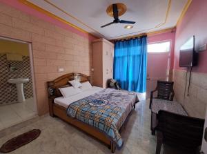 een slaapkamer met een bed en een tv in een kamer bij RIGVEDA Bir Billing in Bir