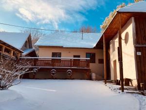 a house with a deck in the snow at Tradičná kopaničiarska chalupa in Košariská-Priepasné