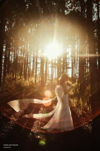 a woman in a white dress standing in a forest at Binh An Village Resort in Da Lat