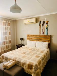 una camera con un grande letto con testiera in legno di Chinaka Game Lodge a Vivo