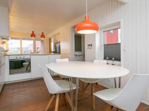 eine Küche und ein Esszimmer mit einem weißen Tisch und Stühlen in der Unterkunft 4 person holiday home on a holiday park in Lemvig in Lemvig
