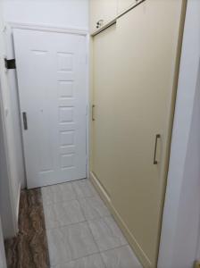um quarto com duas portas brancas e um piso de azulejo em apartman Eva em Hurghada