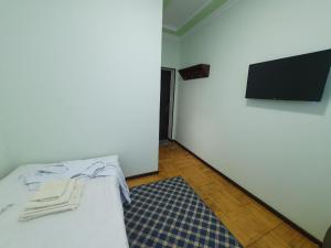 1 dormitorio con 1 cama y TV en la pared en Qarshi hotel Bahor, en Qarshi