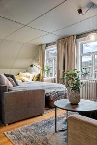 a bedroom with a bed and a couch and a table at Venture Vacations-Cultural Gem in the Heart of Central Reykjavík in Reykjavík