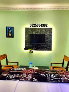 a bedroom with a bed and a tv on the wall at Yelagiri GoldHill Resort in Yelagiri