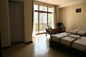 um quarto com 2 camas, uma secretária e uma janela em Honey Guest House em Lalibela