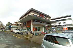 a building with motorcycles parked in a parking lot at OYO 90091 Hi Inn in Sibu