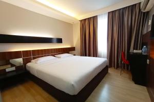 a hotel room with a large white bed and a window at OYO 90091 Hi Inn in Sibu