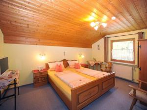 a bedroom with a large bed with a wooden ceiling at Holiday apartment Sonnenfels II in Bodenmais