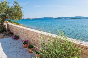 a retaining wall with potted plants next to a body of water at San Antonio mobile homes in Biograd na Moru