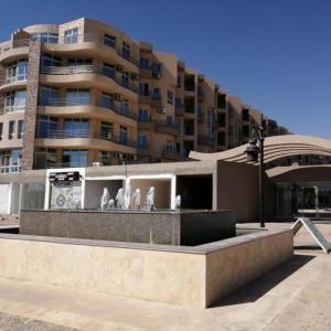 een groot appartementencomplex met een fontein ervoor bij Apartman Princess 148a in Hurghada