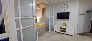 een kleine kamer met een bed en een televisie bij Apartman Princess 148a in Hurghada