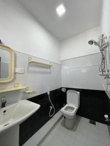 La salle de bains est pourvue de toilettes blanches et d'un lavabo. dans l'établissement VIP Hotel And Villa, à Beruwala