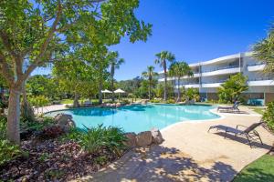 a swimming pool in front of a building at Cotton Beach on the Pool 66 in Casuarina