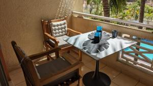 a table and chairs sitting on a balcony at Charming apartment close to beach & amenities - Appartement de charme proche plage in Flic-en-Flac