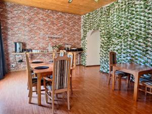 a dining room with tables and chairs and a brick wall at Molopo Naledi Guest Lodge in Vryburg