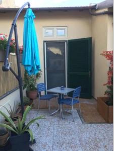 a patio with a table and chairs and an umbrella at monolocale con soppalco per coppie in Marina di Pisa