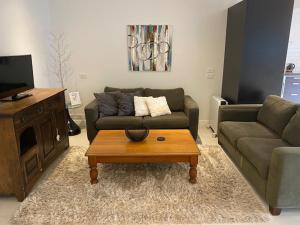 uma sala de estar com um sofá e uma mesa de centro em Thornleigh em Auckland