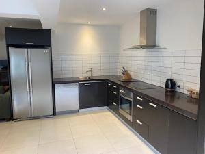 a kitchen with a stainless steel refrigerator in it at Thornleigh in Auckland