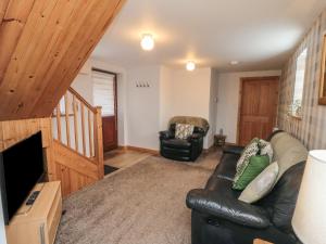 a living room with a couch and a television at Farm Yard Cottage in Pickering