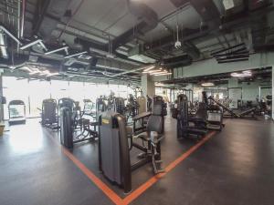 a gym with rows of exercise equipment in a room at Trinity Holiday Homes - Polo Residences Meydan in Dubai
