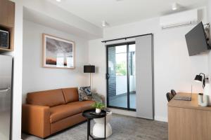 a living room with a couch and a sliding glass door at Amica Serviced Apartments in Orange