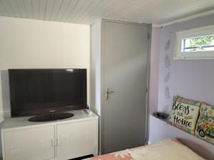 a bedroom with a flat screen tv on a white cabinet at Studio très calme 5mn VICHY in Bellerive-sur-Allier