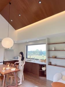 a woman standing in a kitchen with a table at On Stay Jeju in Jeju