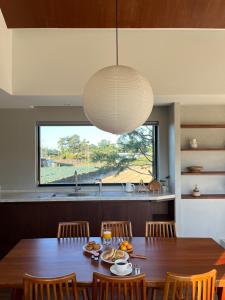 a dining room with a table and a large window at On Stay Jeju in Jeju