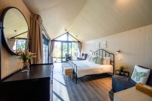 a bedroom with a bed and a mirror in a room at Thara Dara Khaoyai in Ban Tha Maprang