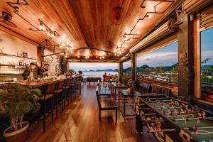 un restaurante con mesas y sillas y vistas al océano en Catba Pod Hostel en Cat Ba