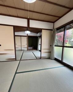 um quarto vazio com grandes janelas num edifício em さぬきリトリート 繋安芯堂 em Kawashima