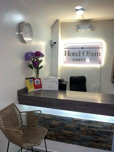 una camera d'albergo con reception e orologio di Hotel Olam Confort a Villavicencio