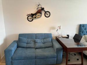 sala de estar con sofá azul y motocicleta en la pared en El corazón de Bogotá en tu ARBNB, en Bogotá
