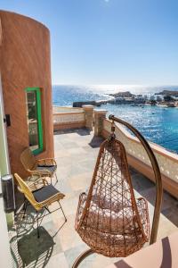 balcone con sedie e vista sull'acqua di La Scala Luxury Villas (Jacuzzi) a Karpathos