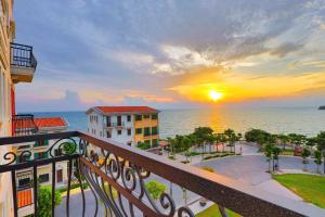 un balcón con vistas al océano al atardecer en Hi Beach House Phu Quoc - Sunset Town en Phu Quoc