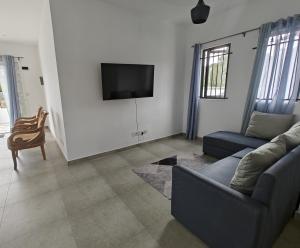 a living room with a couch and a tv at Villa Sakura in Poste Lafayette