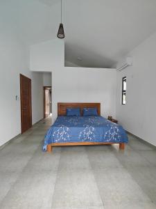 a bedroom with a blue bed in a white room at Villa Sakura in Poste Lafayette