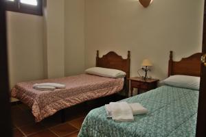 a room with two beds with towels on them at Castillo con piscina en plena Sierra Calderona in Segorbe