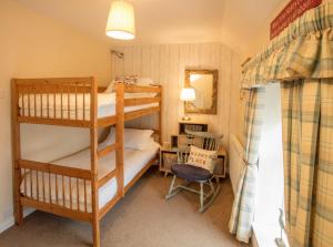 a bedroom with two bunk beds and a chair at Old Post Office in Amlwch