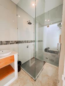 a bathroom with a glass shower and a sink at Apple Villas & Apartments in Kerobokan