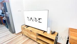 a flat screen tv sitting on top of a wooden dresser at Rare Holiday Homes - Studio in The Crescent Tower A IMPZ Next to Maesim City Centre- R1503 in Dubai