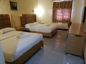 una camera d'albergo con due letti e una finestra di Asia Novo Boutique Hotel - Midsayap a Midsayap