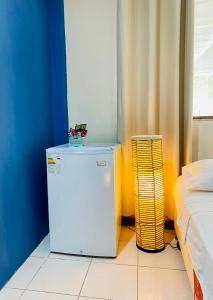 a small white refrigerator in a room with a bed at Casa Johans in Piura