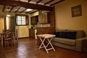 una sala de estar con un sofá y una mesa en Masia de San Juan - castillo con piscina en plena Sierra Calderona, en Segorbe