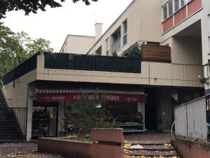a building with a store in front of it at Charmant duplex aux portes de Paris in Bagneux