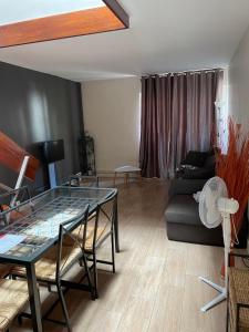 a living room with a glass table and a couch at Charmant duplex aux portes de Paris in Bagneux +23 photos